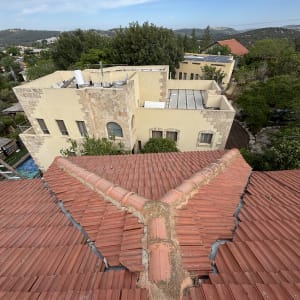 גג רעפים אדום עם חיבור מרכזי ותיקונים