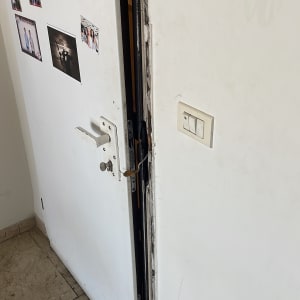 דלת לבנה עם מנעול ותמונות קטנות על הקיר