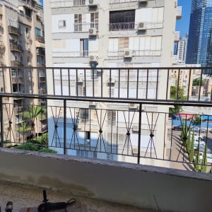מעקה מתכת במרפסת עם כלים על הרצפה
