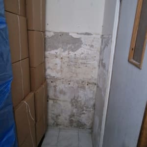 קופסאות קרטון מוערמות ליד קיר מתקלף