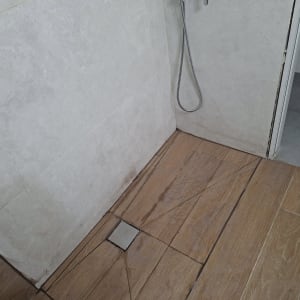 רצפת מקלחת עם אריחים ומקלחת יד