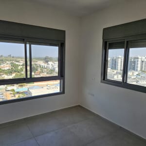 חדר ריק עם חלונות גדולים ונוף עירוני