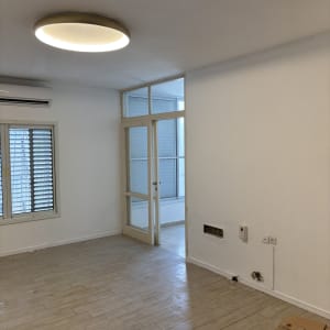 חדר צבוע עם רצפת עץ ותאורה עגולה בתקרה