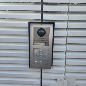 אינטרקום עם מצלמה ומקשים על קיר לבן