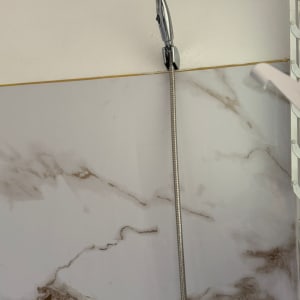 ראש מקלחת על קיר שיש בחדר אמבטיה