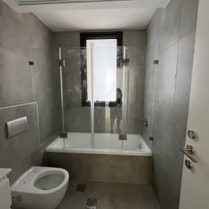 חדר אמבטיה עם מקלחון זכוכית ואסלה