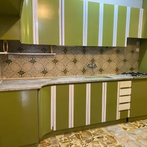 מטבח עם ארונות ירוקים וכיור לניקוי