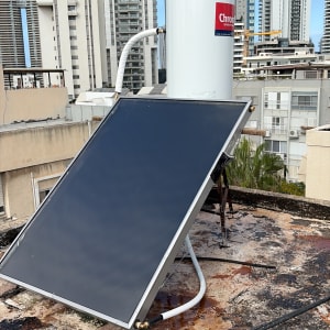 דוד שמש על גג עם רקע של בניינים גבוהים