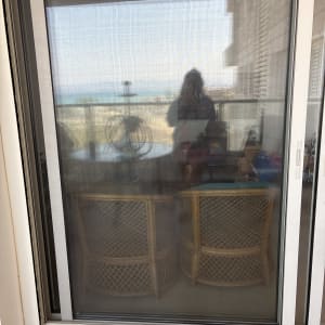 דלת זכוכית עם רשת ומרפסת ברקע