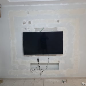 טלוויזיה מותקנת על קיר עם תיקוני טיח