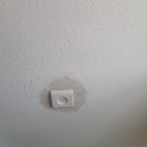 שקע חשמל בקיר עם טיח מסביב