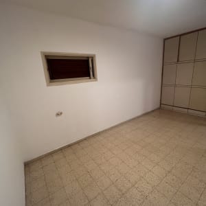 חדר ריק עם קירות לבנים ורצפת אריחים