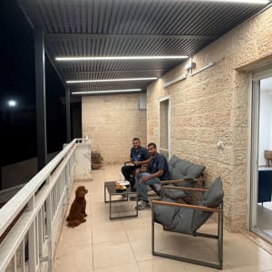מרפסת עם פרגולה אלומיניום ושני אנשים יושבים