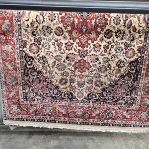 שטיח צבעוני תלוי לייבוש על מתקן מתכת