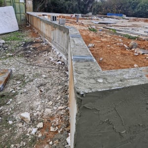 קיר בטון עם טיח טרי באתר בנייה