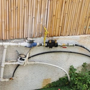 צנרת מים עם מד מים וברזים מחוברים לקיר