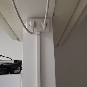 שקע חשמל עם כבלים מחוברים על קיר לבן