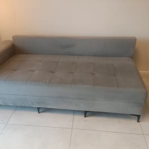 ספה אפורה עם כתמים קלים על הרצפה