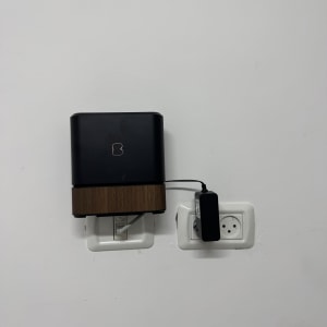 מכשיר מחובר לשקע חשמל על קיר לבן