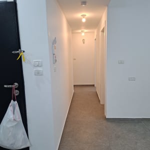 מסדרון עם תאורה ודלת עם שקית תלויה