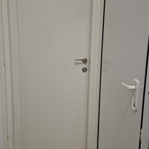 דלת לבנה סגורה ודלת נוספת פתוחה עם ידית לבנה