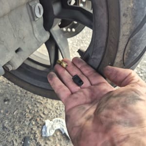 יד מלוכלכת מחזיקה חלקים ליד גלגל רכב