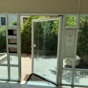 דלת זכוכית פתוחה עם מסגרת לבנה