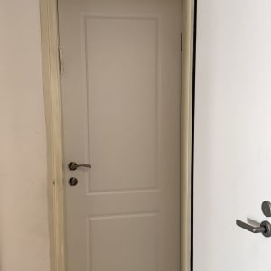 דלת לבנה עם ידית מתכת כסופה פתוחה חלקית