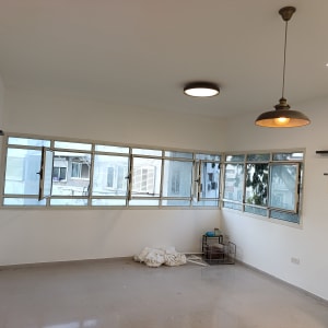 חדר צבוע עם חלונות פתוחים ותאורה תלויה