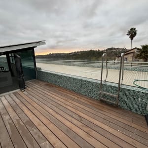 דק עץ ליד בריכה עם נוף הררי