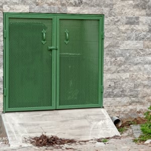 דלת מתכת ירוקה עם מסגרת על קיר אבן אפור