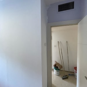 קיר גבס עם דלי צבע וכלי עבודה