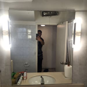 מראה גדולה עם כיור וברז בחדר אמבטיה