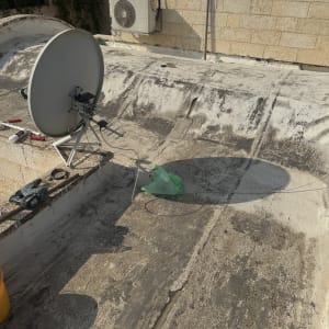 תמונה של גג עם צלחת לוויין וכלים, קשור לאיטום