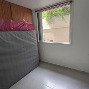 חדר ריק עם חלון פתוח ומזרן שעון על הקיר