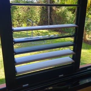 תריסים פתוחים עם כלים על אדן החלון