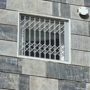 חלון עם סורגים על קיר אבן אפור