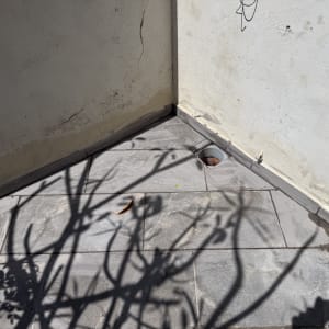 פינת קיר עם אריחים וסדקים בקיר