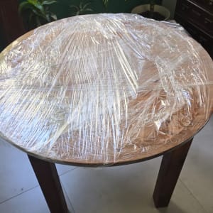 שולחן עץ עגול עטוף בניילון נצמד להגנה לקראת הובלת דירה