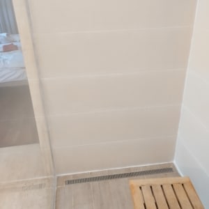 מקלחון עם ניקוז רצפה וספסל עץ