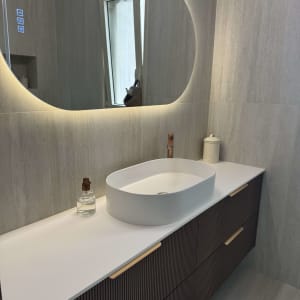 חדר אמבטיה מעוצב עם כיור ומראה מוארת