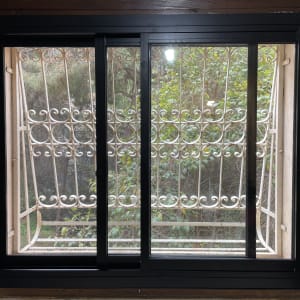 חלון אלומיניום עם מסגרת שחורה וסורגים מעוצבים
