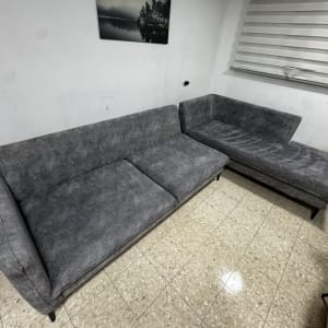 ספה אפורה בחדר עם רצפת אריחים