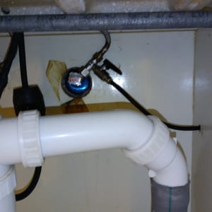 צינור פלסטיק לבן עם מחברים מתחת לכיור