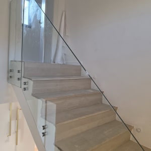 מעקה זכוכית על מדרגות עץ בבית מודרני