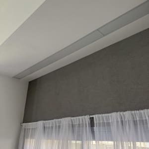 וילון לבן על חלון עם קיר צבוע