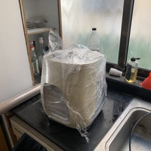 מכשיר עטוף בניילון על משטח מטבח ליד כיור