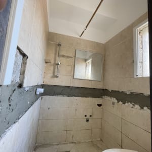 חדר אמבטיה בשיפוץ עם אריחים ומראה