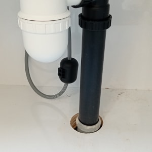 צנרת פלסטיק לבנה ושחורה מתחת לכיור