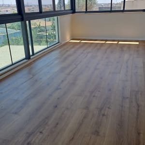 רצפת פרקט בחדר עם חלונות גדולים